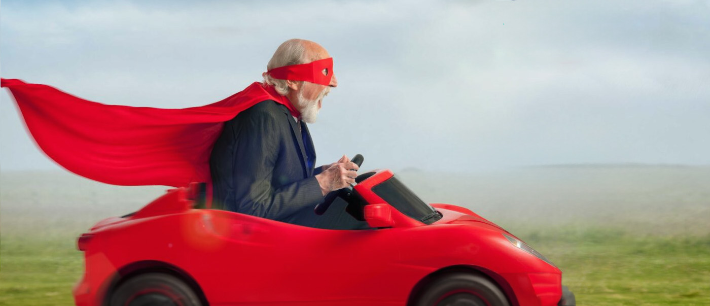 a man in a red cape driving a red car